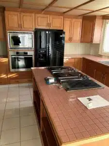 A kitchen with a black refrigerator and stove

Description automatically generated